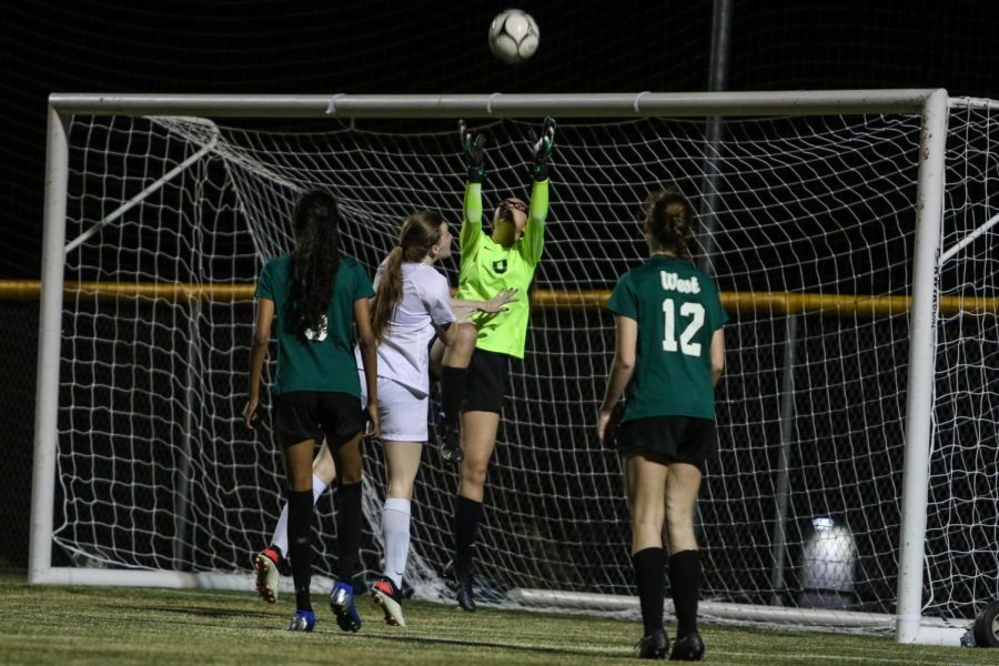 Julia Bernat '21 jumps into the air to make a save against Ankeny on April 6.