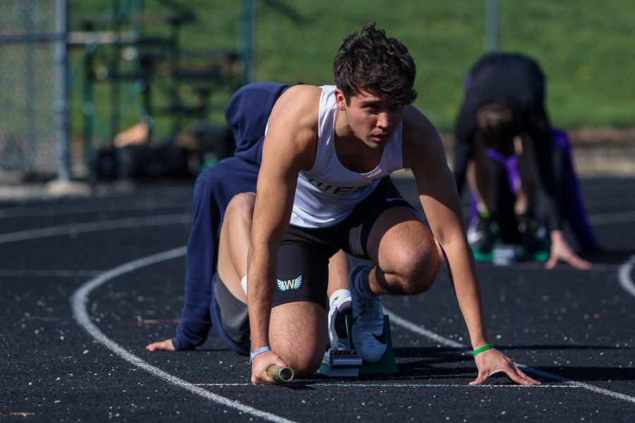 Eric Torres '21 settles into his blocks before the start of the sprint medley relay during the Eastern Iowa Track and Field Festival on April 12.