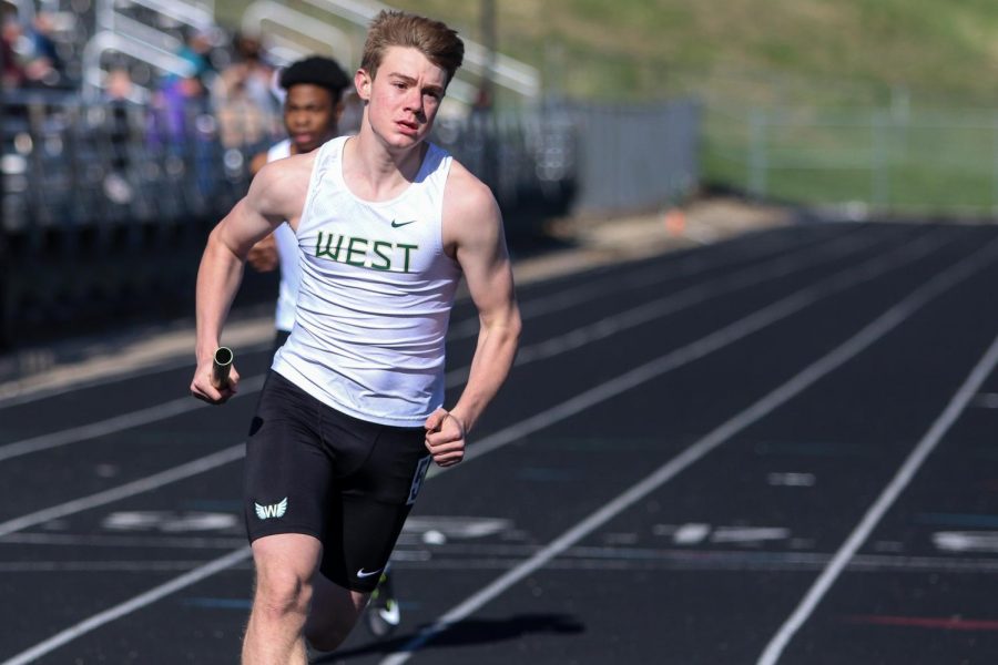 Aidan Jacobsen '24 looks into the turn while running in the sprint medley relay during the Eastern Iowa Track and Field Festival on April 12.