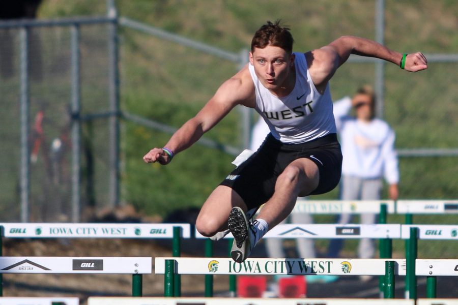 Christian Janis '23 competes in the shuttle hurdle relay during the Eastern Iowa Track and Field Festival on April 12.