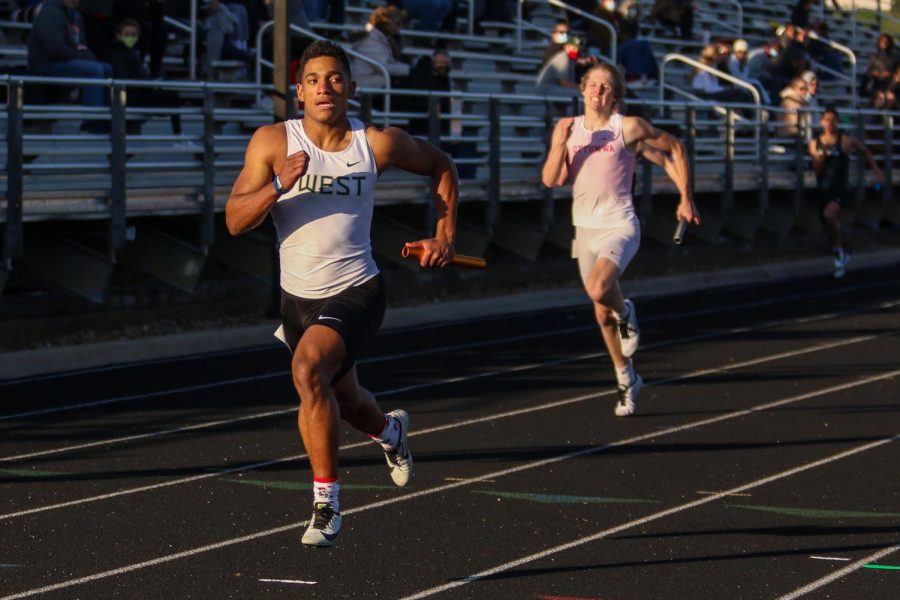 Mason Applegate '22 eyes his competition as he wins the 4 by 200 meter race during the Eastern Iowa Track and Field Festival on April 12.