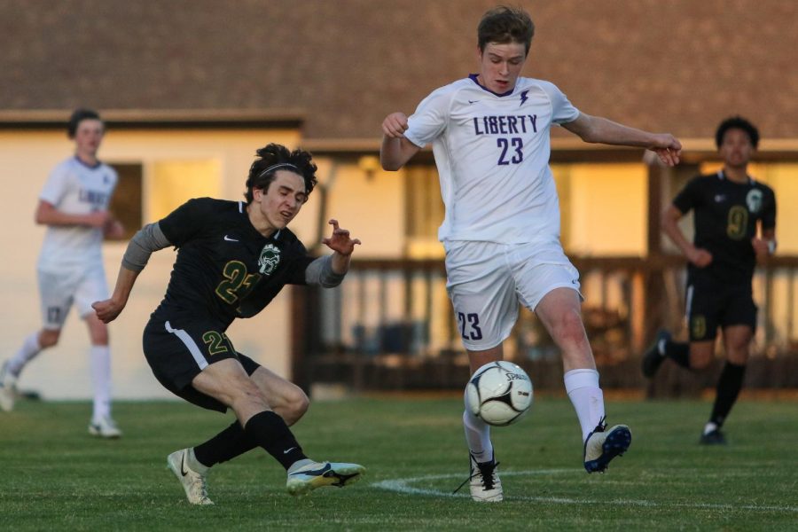 Michael Nelson '23 puts a shot on goal past his defender against Liberty on April 13.