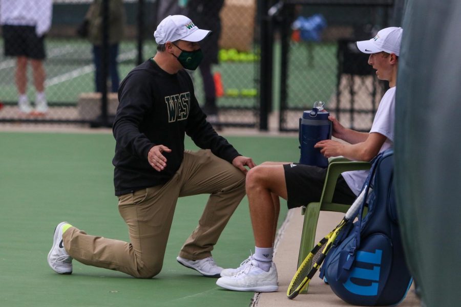 Head coach Mitch Gross talks to Eli Young '21 between sets against Cedar Rapids Washington on April 14.