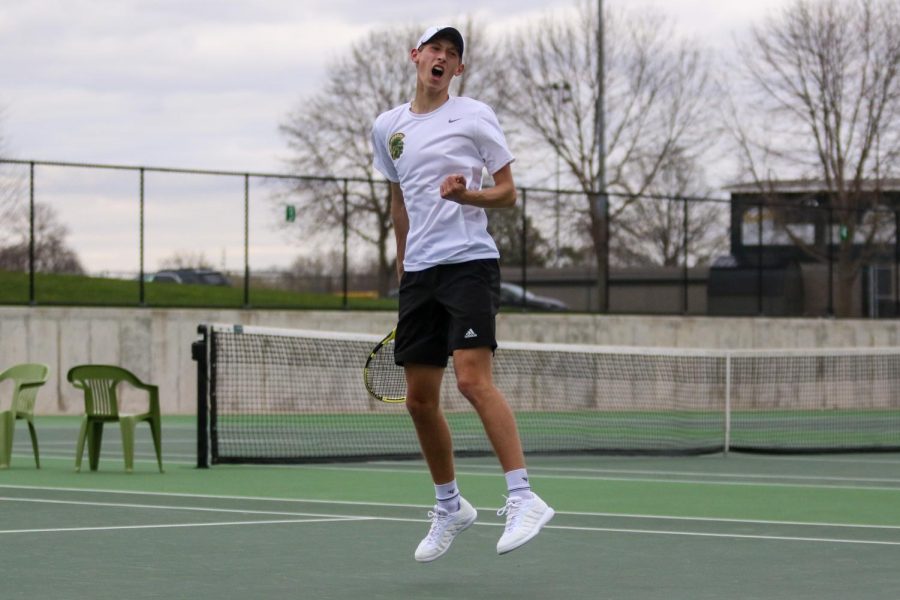 Eli Young '21 jumps into the air while celebrating a point against Cedar Rapids Washington on April 14.