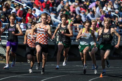 Alex McKane 22 and Seth Cheney 23 try to separate from the crowd at the start of the 3200-meter race at the Class 4A district track and field meet on May 13.