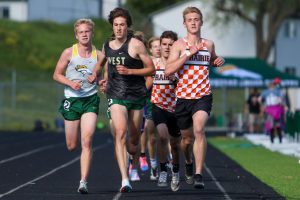 Alex McKane 22 leads the pack while running the 3200-meter race at the Class 4A district track and field meet on May 13.