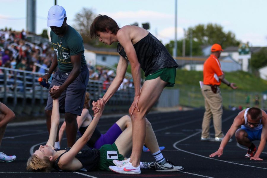 Alex McKane '22 and Steve Tembea '22 help up Seth Cheney '23 after he finished the 3200-meter race at the Class 4A district track and field meet on May 13.