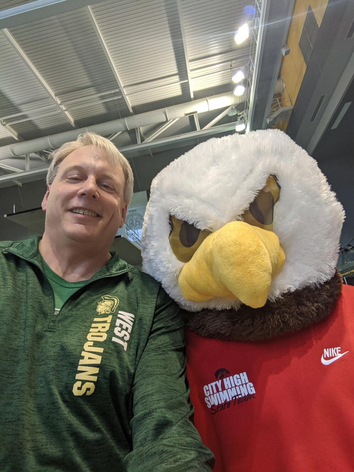 Dr. Shoultz taking a selfie with City high swimming team mascot. 