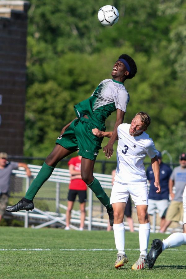 Amre Ibrahim '23 jumps into the air to head the ball against Pleasant Valley in the state championship game on June 5 in Des Moines.