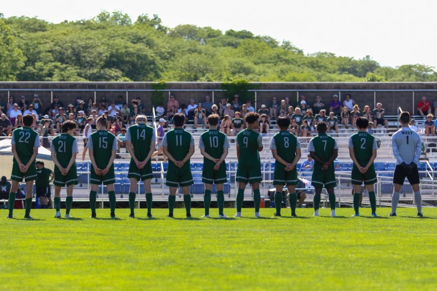 The boys soccer team stands while starters are announced before playing Pleasant Valley in the state championship game on June 5 in Des Moines.