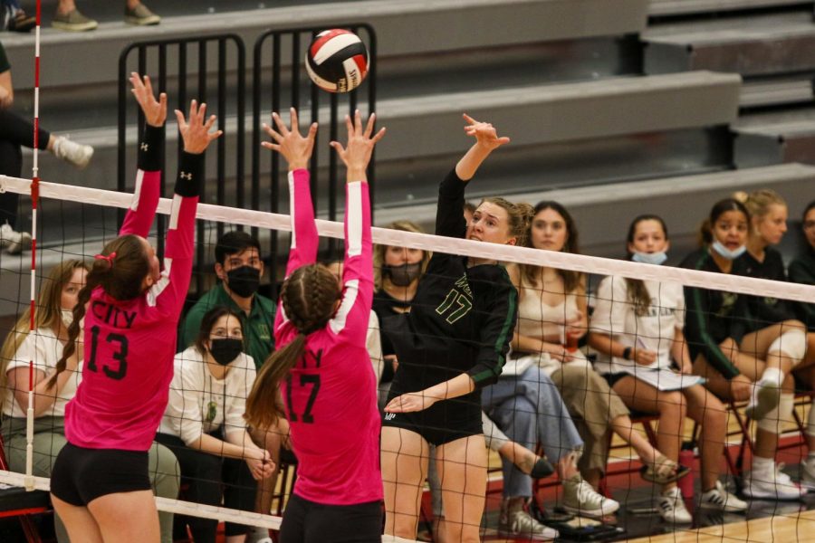 Raina Pfeifer '22 hits the ball over two City High blockers in search of a point during the Battle for the Spike at City High on Sept. 30.