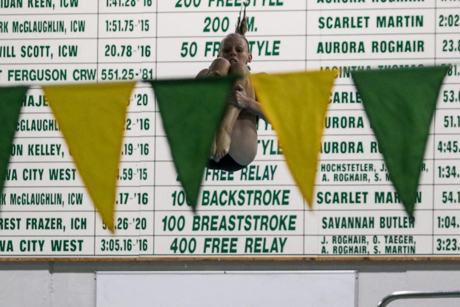 Kamila Swanson '25 tumbles in the air while competing in the first round of diving on Sept. 2 in a dual meet against Waterloo at the Coralville Rec Center.