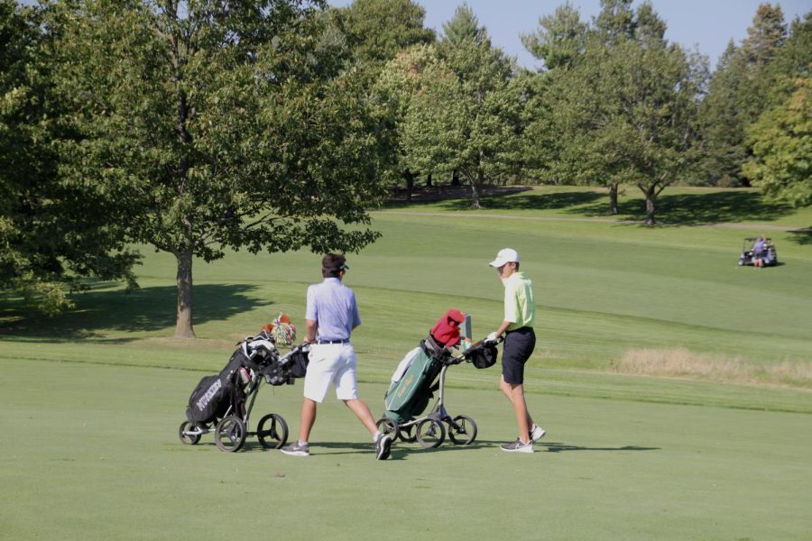 Harrison Reimers 23 pushes his clubs through the course during a tournament. 