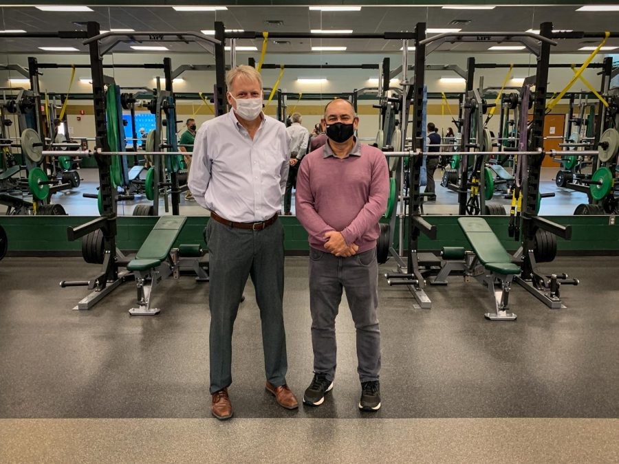 Dr. Gregg Shoultz and Greg Hughes pose for a photo inside the West High weight room while touring the school on Oct. 26.