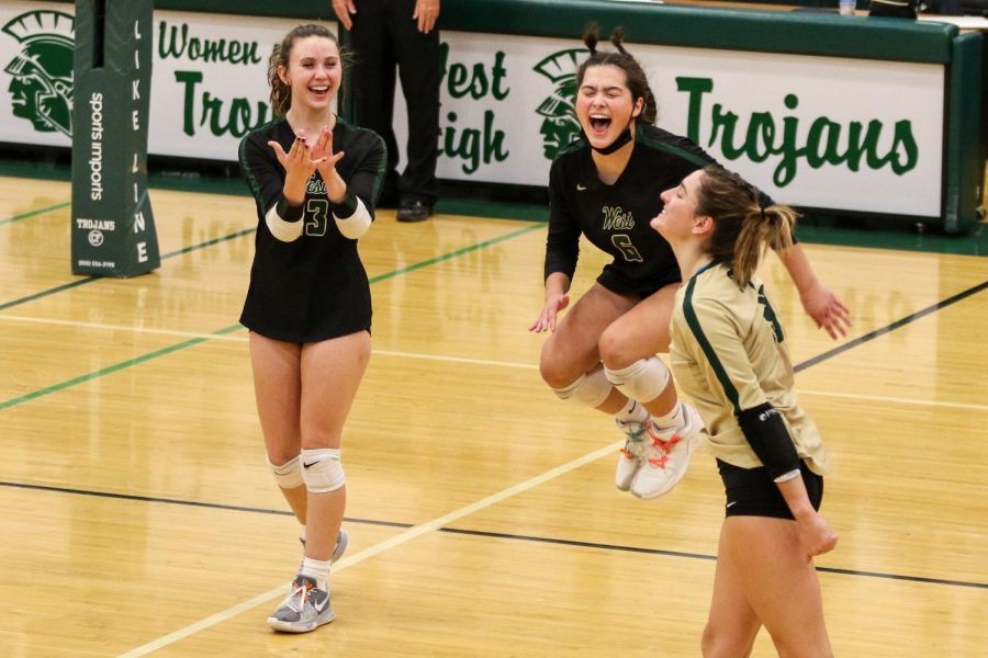 Emma Dunlap '22 and Alaina Greelee '23 celebrate a Katherine Kouba '22 ace on Oct. 21 during the regional semifinal against Bettendorf.