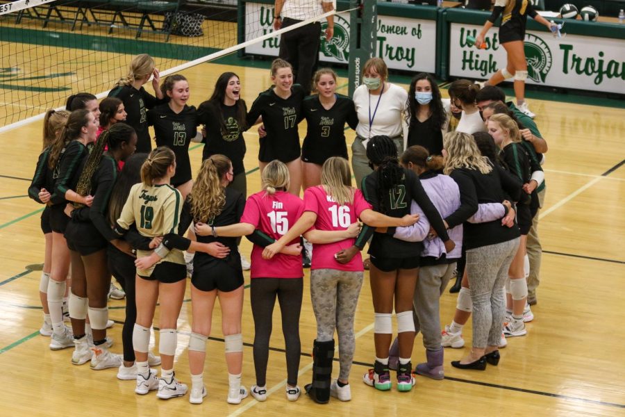 The Trojan volleyball team comes together after defeating Bettendorf on Oct. 21 and advancing to the regional final game.