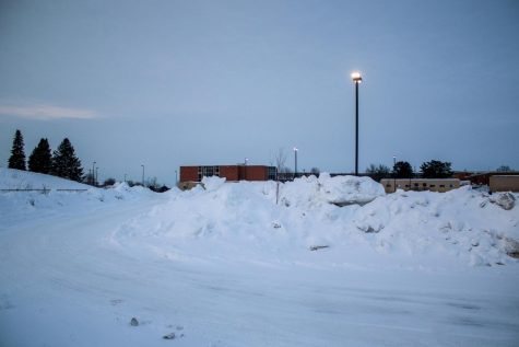 The West High parking lot sits empty as snow removal crews start to clear the snow on Feb. 7, 2021.