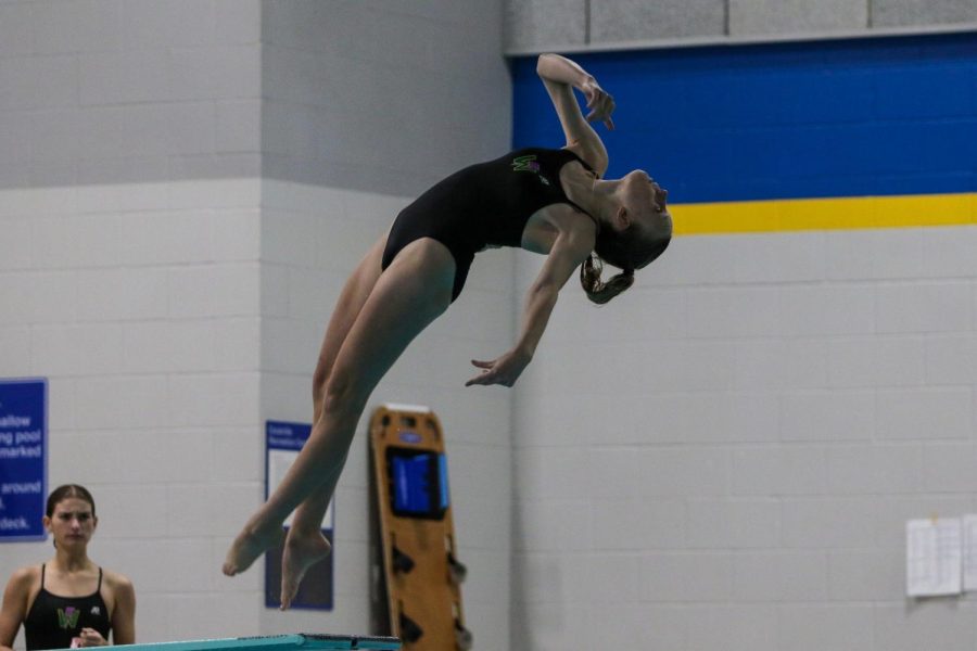 Kamila Swanson '25 twists and turns in mid-air while diving in the final round of the night on Oct. 19 during a dual meet against City High.  