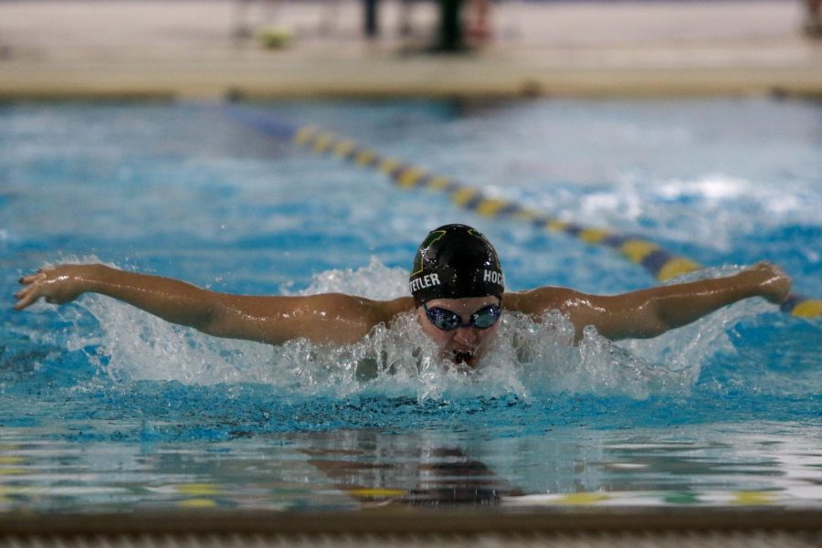 Ella Hochstetler '22 comes up to take a breath while swimming the 100 yard butterfly on Oct. 19 during a dual meet against City High.