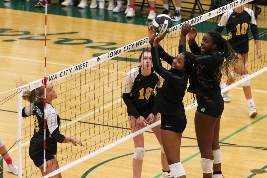 Melae' Lacy '24 and Mayowa Dokun '22 watch the ball head out of bounds after attempting a block on Oct. 21 during the regional semifinal against Bettendorf.