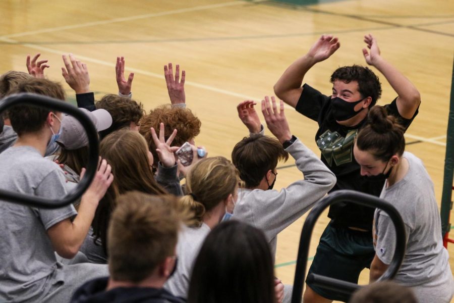 Ryan Goodman '23 does the rollercoaster with the student section between sets on Oct. 21 during the regional semifinal against Bettendorf.