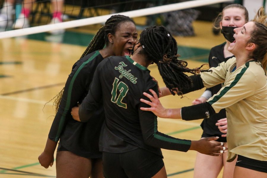 Mayowa Dokun '22 and Katherine Kouba '22 celebrate a Melae' Lacy '24 kill on Oct. 21 during the regional semifinal against Bettendorf.