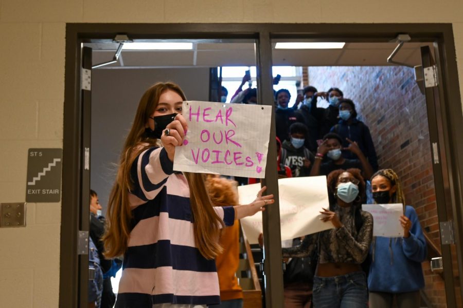 Ava Conrads 23 holds a sign while protesting Nov. 8. 