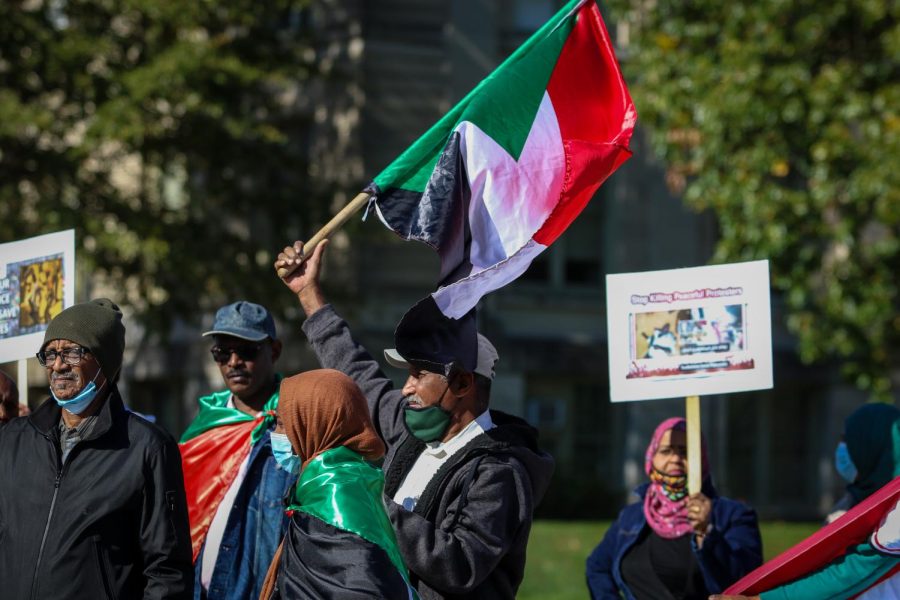 A man waves the Sudanese flag while protesting the military coup in Sudan at the Pentacrest in downtown Iowa City on Oct. 30. 