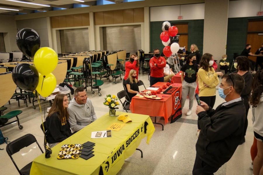 Friends and family take pictures of their athletes during the signing ceremony in the cafeteria after school on Nov. 10.