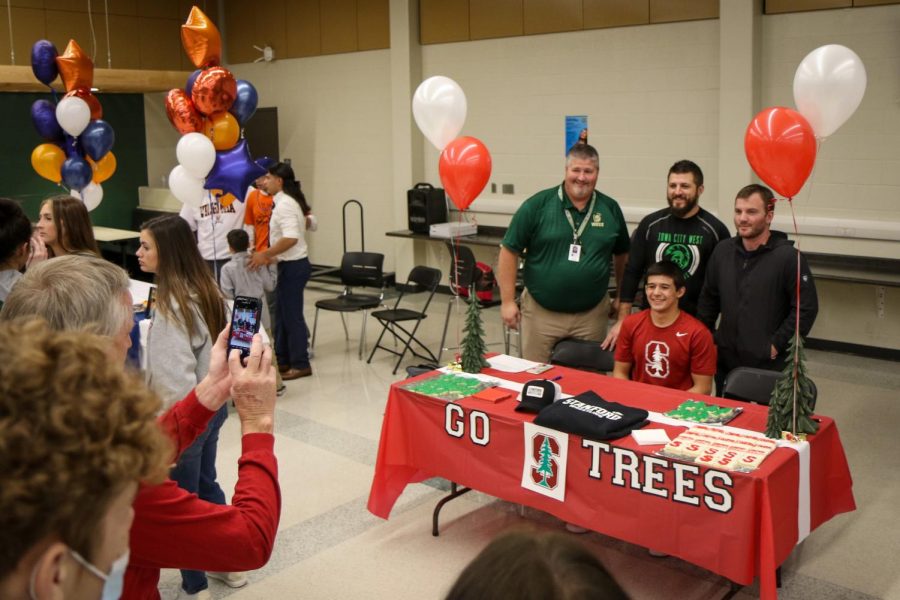 Friends and family take pictures of their athletes during the signing ceremony in the cafeteria after school on Nov. 10.