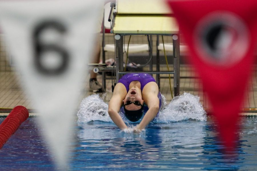 Carlee Wilkins '24 flies off the blocks at the start of the 100 yard backstroke during the IGHSAU State Swimming and Diving Championships in Marshalltown on Nov. 13.