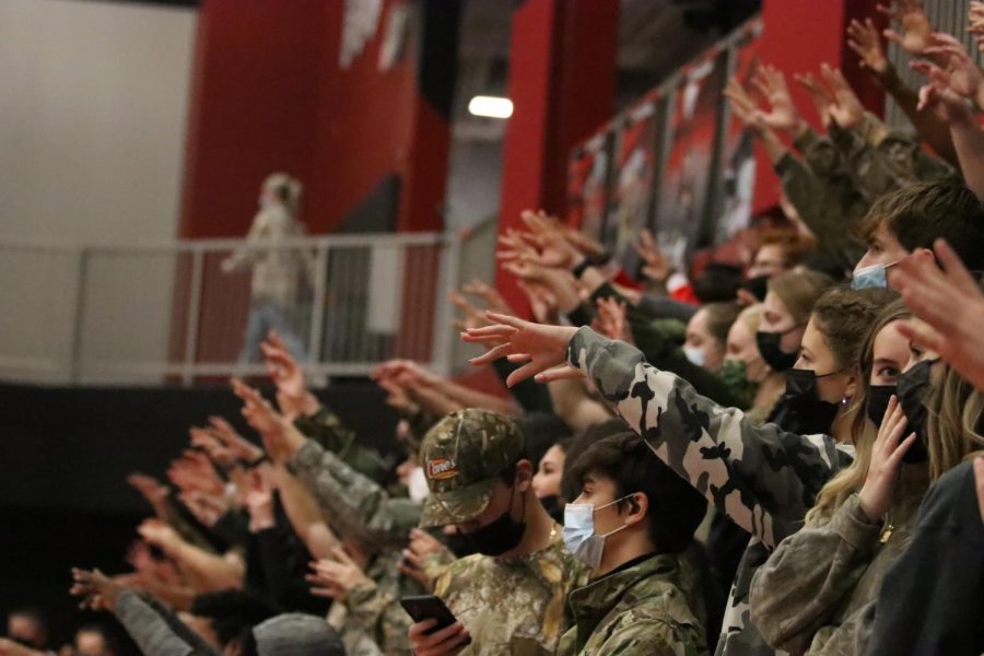 The student section cheers on the Trojans sporting the traditional camo-out for the City vs. West rivalry games on Dec. 17.