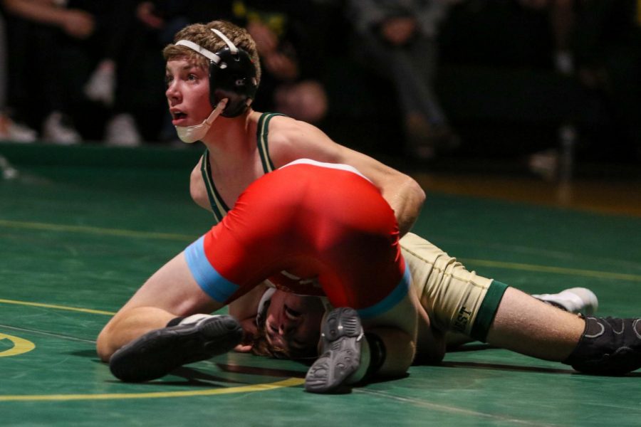 Braden Doyle 24 looks up at the clock as he wrestles his opponent during a dual meet against Dubuque Senior on Dec. 9.