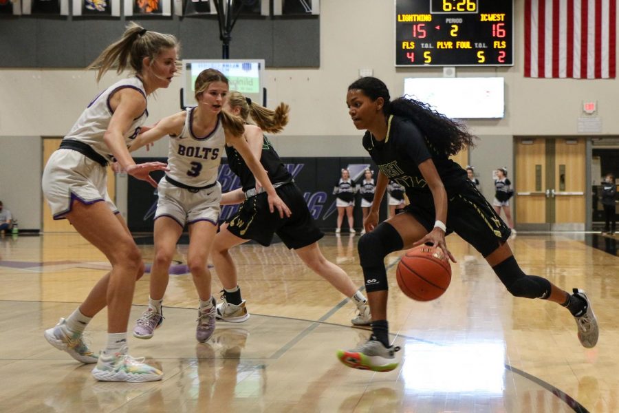 Meena Tate '23 drives past two Lightning defenders and into the paint against cross-town rival Liberty on Dec. 10.