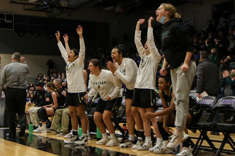 The girls basketball team bench celebrates junior Carolyn Pierces three against cross-town rival Liberty on Dec. 10.