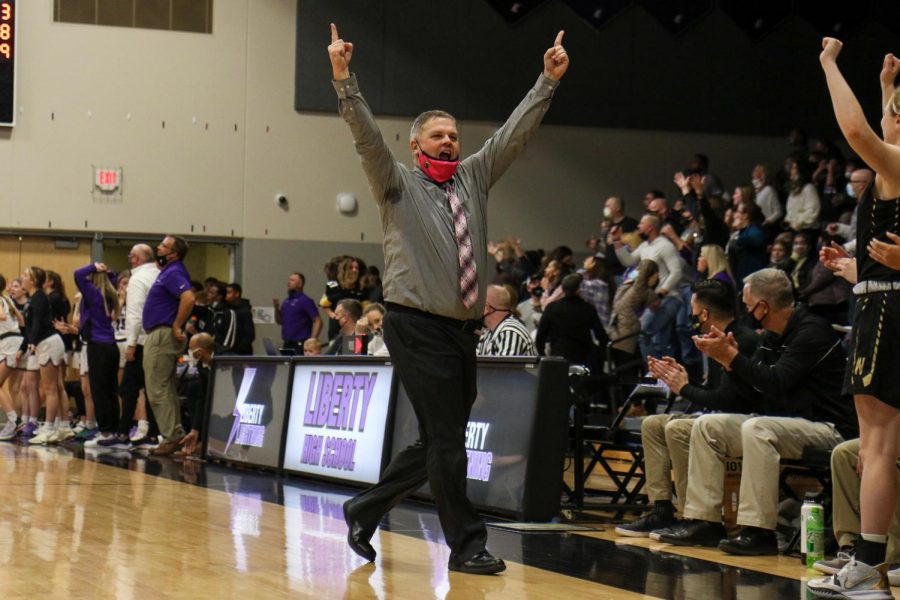 Head Coach BJ Mayer celebrates the Trojans win over their cross-town rival Liberty on Dec. 10.