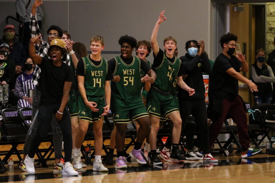 The boys basketball team bench celebrates a Savion Taylor 23 three against cross-town rival Liberty on Dec. 10.