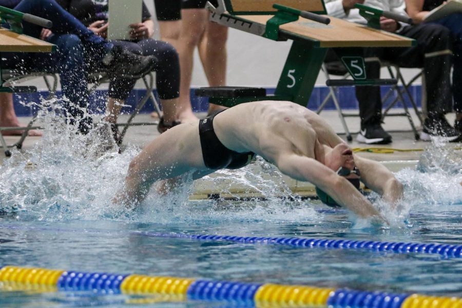 Kirk Brotherton 22 hits the water at the start of the 100 yard backstroke during a dual meet against Waterloo on Dec. 14.
