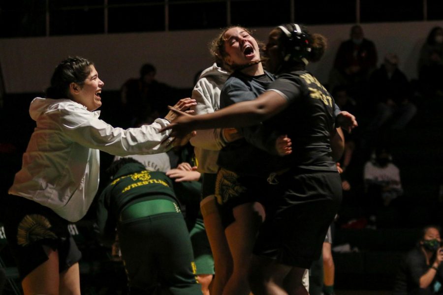 Jannell Avila 23 and Lexi Nash 23 celebrate sophomore Sokona Keitas win by decision during a dual meet against City High on Dec. 22. 