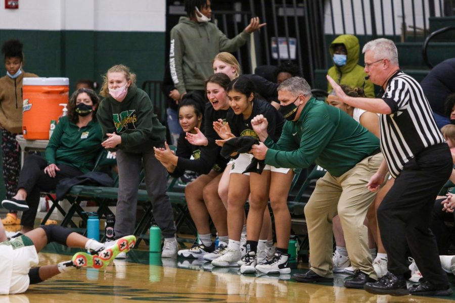 Head Coach BJ Mayer and the rest of the bench celebrates a loose ball play against  Cedar Rapids Washington on Dec. 3.