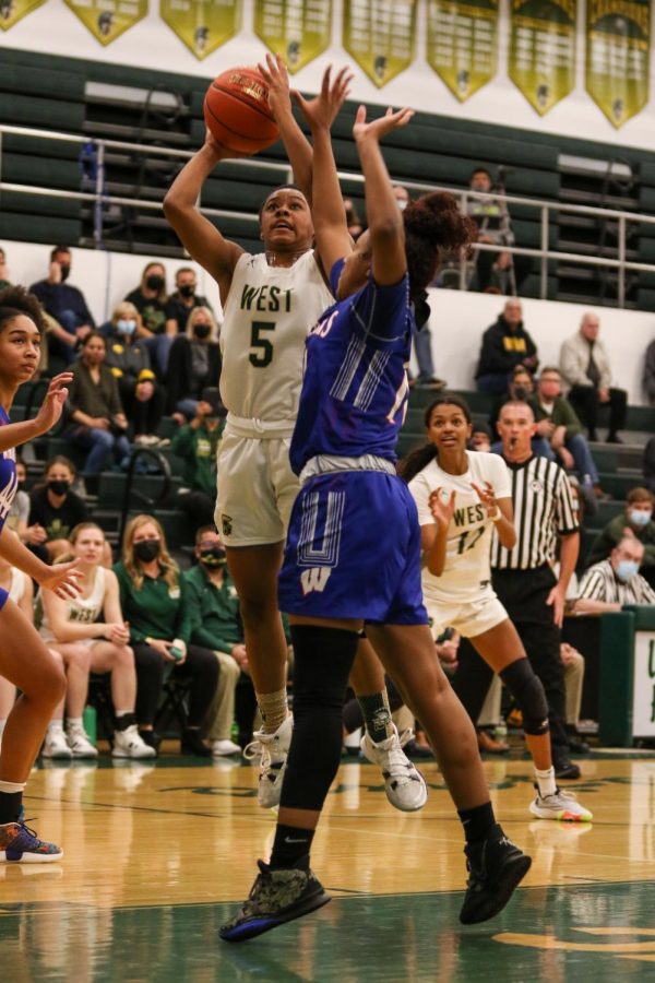 Emma Ingersoll-Weng '22 fights through some contact while going up for a layup against Cedar Rapids Washington on Dec. 3.