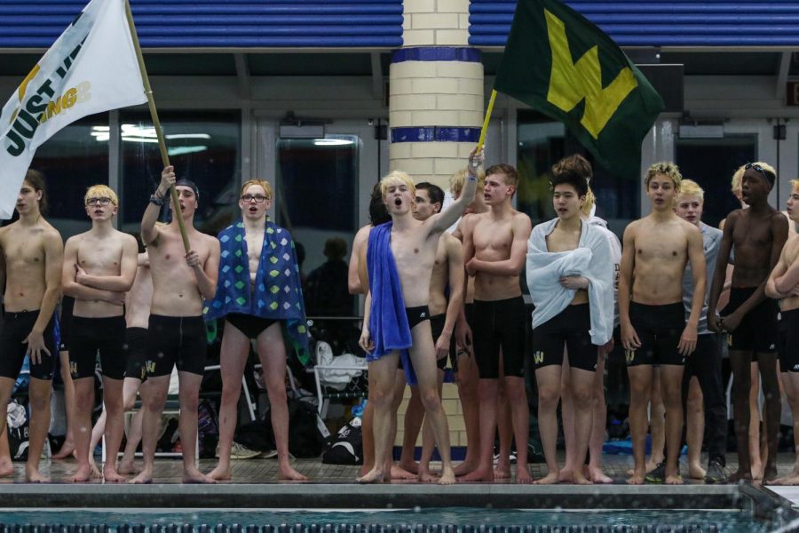 The boys swim team cheers on their teammates during the 400 Freestyle Relay during the annual Battle for the Golden Speedo on Jan. 18.