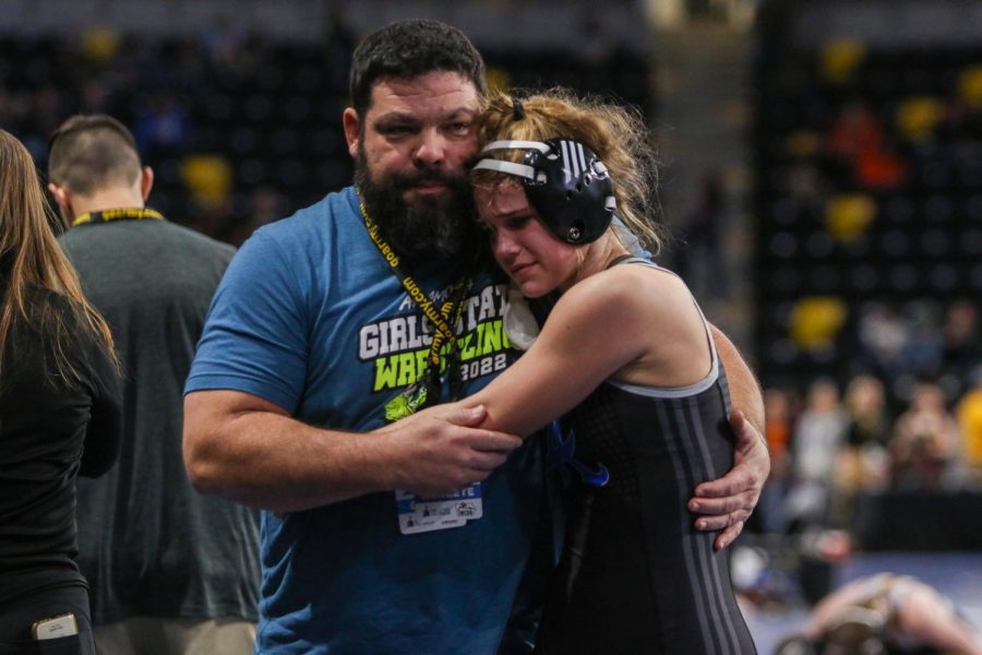An Anamosa coach comforts one of his wrestlers after a tough loss at the Xtream Arena in Coralville during the 2022 girls state wrestling tournament on Jan. 22. 