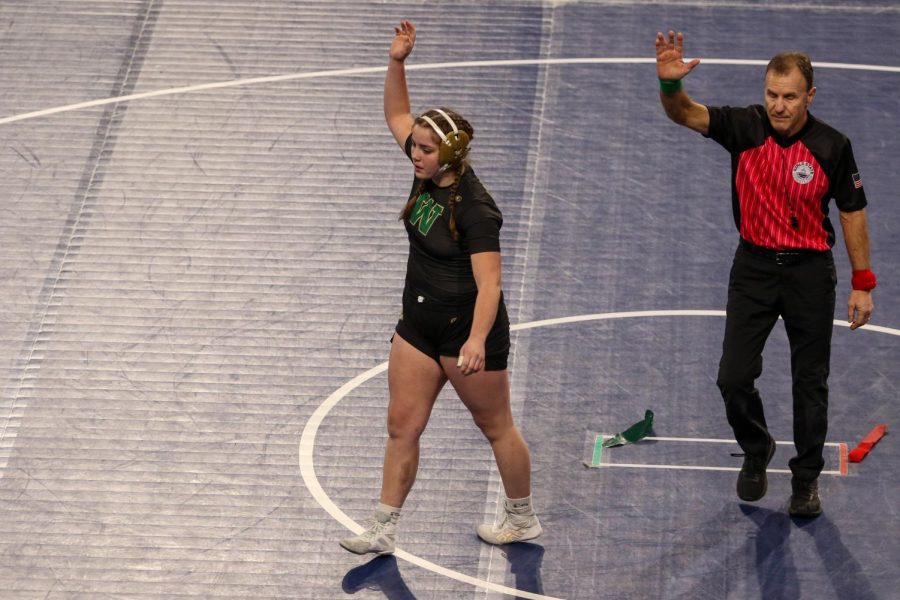Lexi Nash 23 raises her hand after pinning South Winneshieks Isabelle Kipp 23 at the Xtream Arena in Coralville during the 2022 girls state wrestling tournament on Jan. 22.  