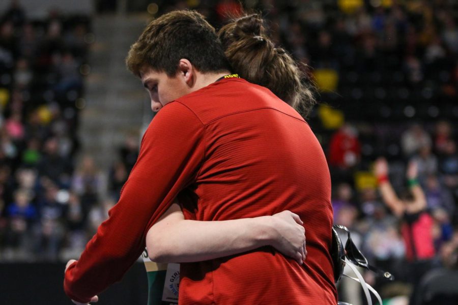 Emma Barker 22 hugs her brother and former Trojan wrestler Ashton Barker 21 after her match at the Xtream Arena in Coralville during the 2022 girls state wrestling tournament on Jan. 22.  