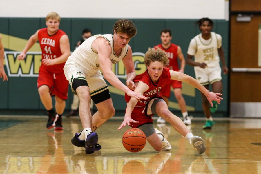 Pete Moe 22 and Cedar Falls Anthony Galvin 25 fight for a loose ball on Jan. 15.