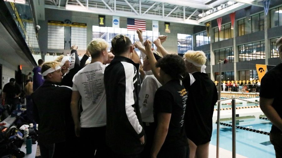 The boys swim team does their cheer before the first race of the meet Feb. 12.