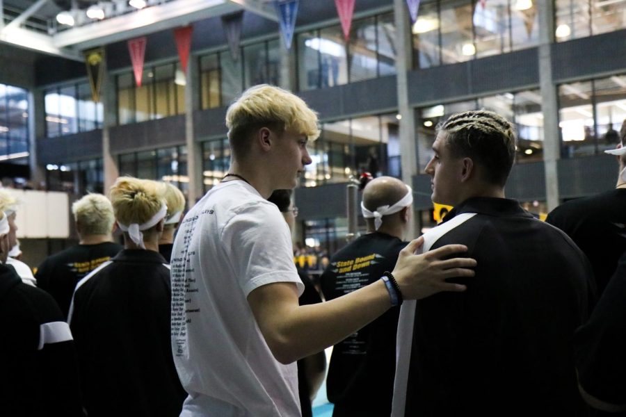Christian Janis 23 talks with Boyd Skelley 22 before the start of the boys state swim meet on Feb. 12.