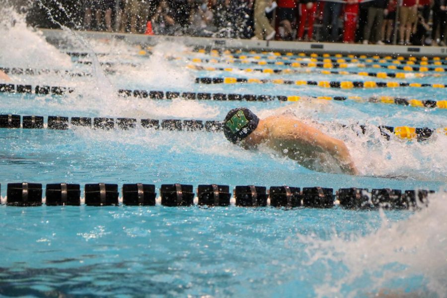 Holden Carter 24 bursts through the pool during the 100 meter butterfly final on Feb. 12.