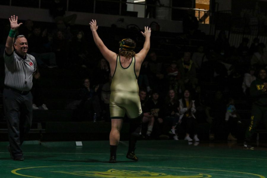 Brett Pelfrey 22 waves to the crowd after winning by forfeit during a dual meet against Waterloo West on Feb. 3.